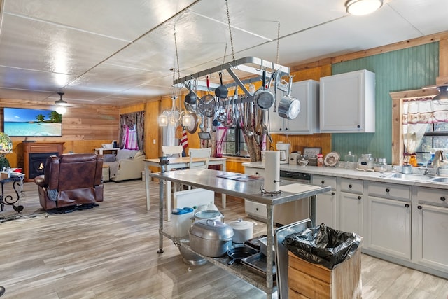 kitchen featuring sink, hanging light fixtures, light hardwood / wood-style flooring, ceiling fan, and white cabinetry