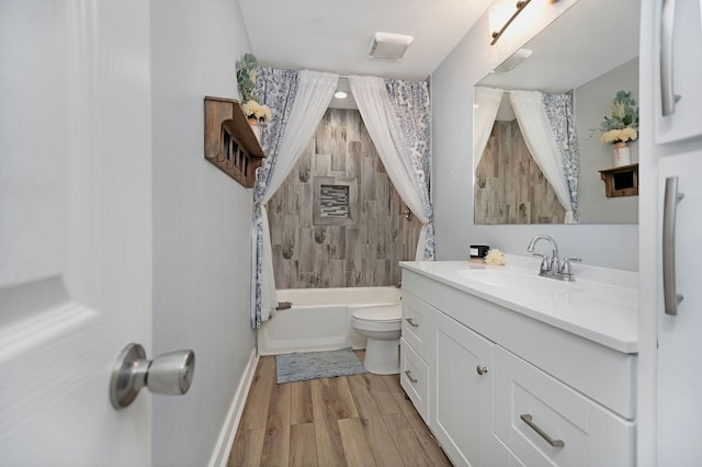 full bathroom featuring hardwood / wood-style flooring, vanity, shower / bath combo, and toilet