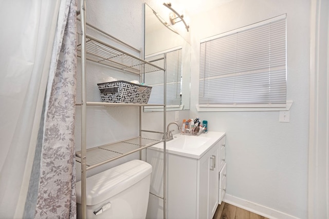 bathroom featuring wood-type flooring, vanity, and toilet