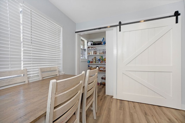 dining space featuring a barn door and light hardwood / wood-style floors