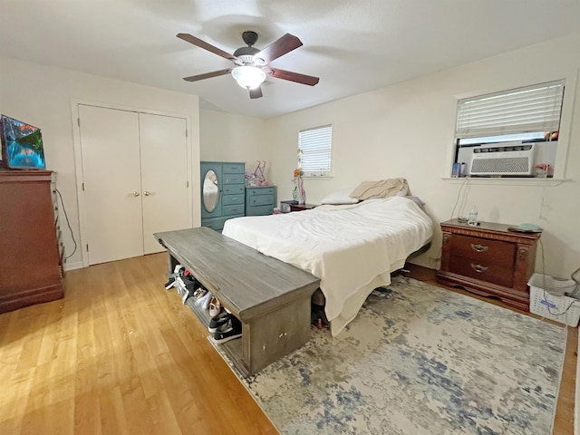 bedroom with a closet, hardwood / wood-style flooring, ceiling fan, and cooling unit