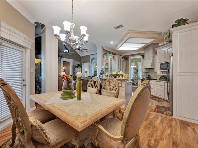 dining area featuring light wood-style flooring, recessed lighting, ceiling fan with notable chandelier, visible vents, and crown molding