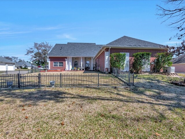 view of front of house with a fenced front yard, a front yard, and brick siding
