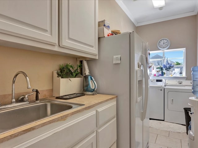 clothes washing area featuring crown molding, light tile patterned floors, a sink, separate washer and dryer, and laundry area