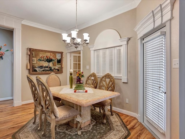 dining space with an inviting chandelier, light wood-style flooring, ornamental molding, and baseboards