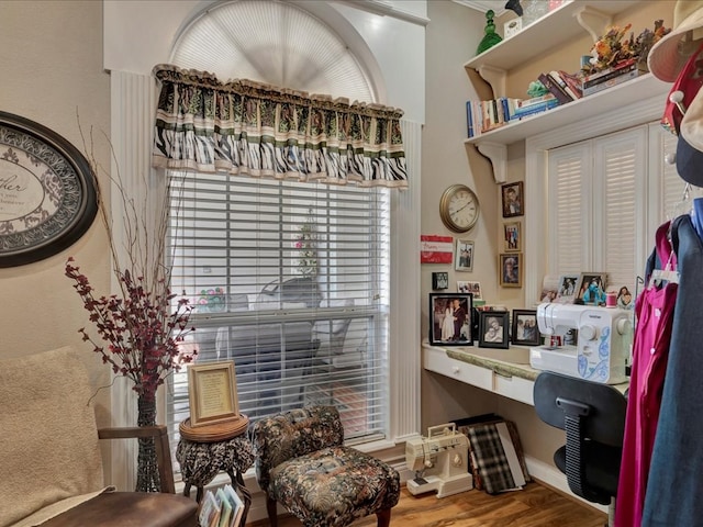interior space with baseboards, built in desk, and wood finished floors