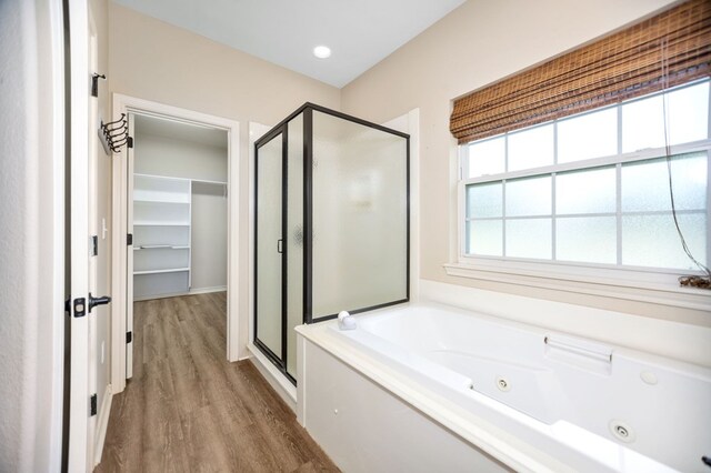 113 Westfield Loop, Lufkin, TX 75904 - bathroom featuring a shower stall, a jetted tub, wood finished floors, and a spacious closet