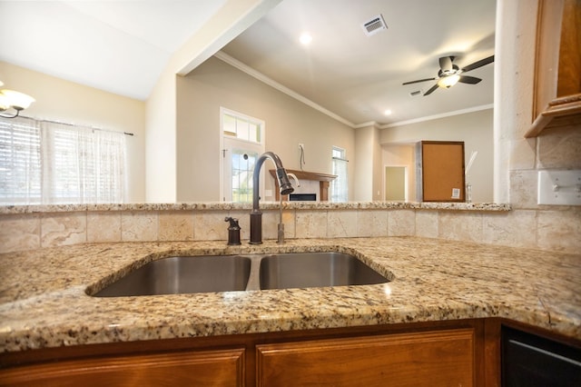 113 Westfield Loop, Lufkin, TX 75904 - kitchen with light stone countertops, ceiling fan, brown cabinets, ornamental molding, and recessed lighting