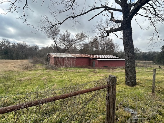 view of yard featuring fence, an outdoor structure, and an outbuilding