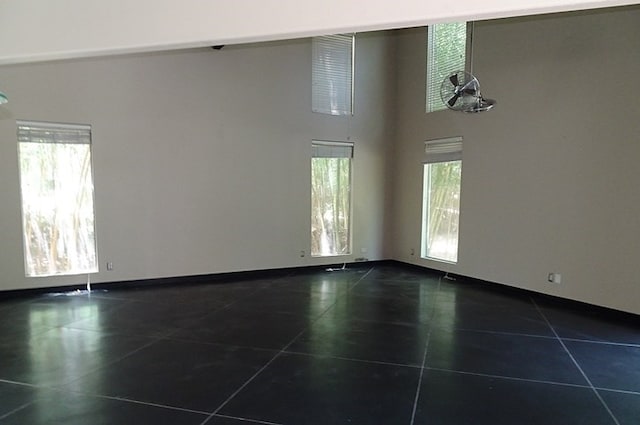 330 Bostwick St, Nacogdoches, TX 75965 - unfurnished room featuring healthy amount of natural light, dark tile patterned floors, and a towering ceiling