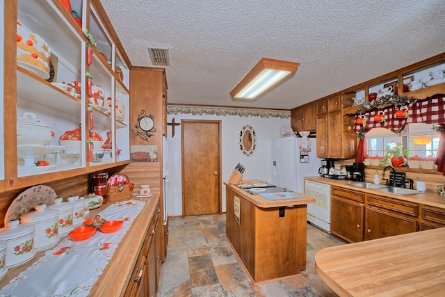 2105 Carters Ferry Rd, E Road, Milam, TX 75959 - kitchen featuring white appliances, a textured ceiling, stone finish floor, visible vents, and a sink