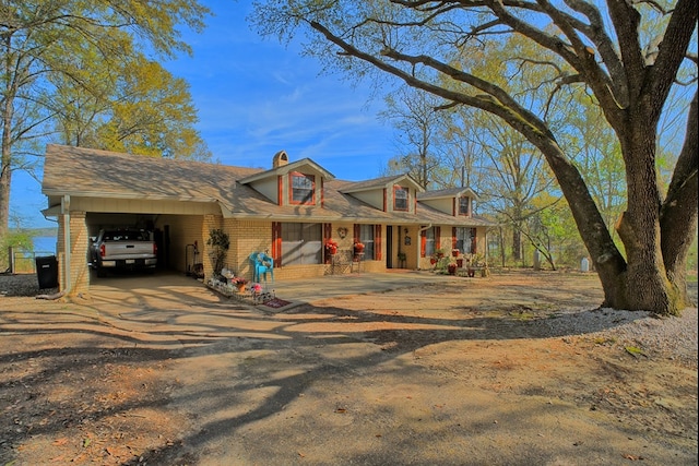 2105 Carters Ferry Rd, E Road, Milam, TX 75959 - cape cod-style house with an attached carport, brick siding, a chimney, a shingled roof, and driveway