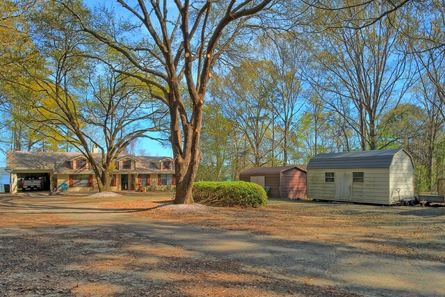 2105 Carters Ferry Rd, E Road, Milam, TX 75959 - view of front facade with a storage shed, a carport, an outbuilding, and dirt driveway