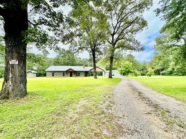 4815 Fm 2827, Warren, TX 77664 - ranch-style house with a front lawn, gravel driveway, and metal roof