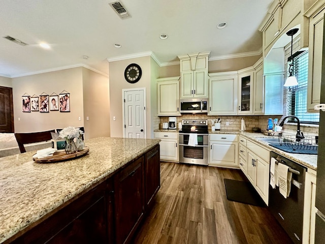 4815 Fm 2827, Warren, TX 77664 - kitchen with appliances with stainless steel finishes, a sink, dark wood-style floors, light stone counters, and decorative backsplash