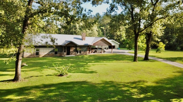 4815 Fm 2827, Warren, TX 77664 - ranch-style home featuring a chimney, a front lawn, stone siding, metal roof, and a standing seam roof
