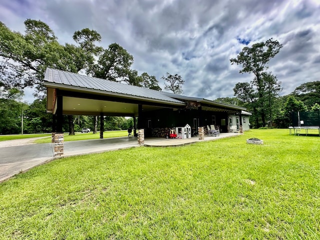 4815 Fm 2827, Warren, TX 77664 - view of property's community featuring a trampoline, a yard, a fire pit, and an attached carport