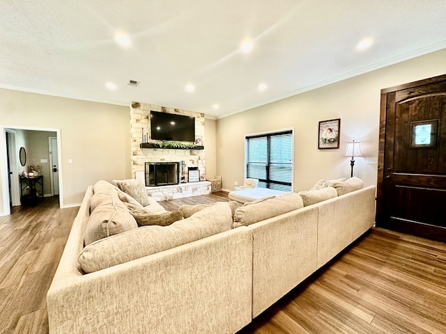 4815 Fm 2827, Warren, TX 77664 - living area with wood finished floors, a stone fireplace, crown molding, recessed lighting, and baseboards
