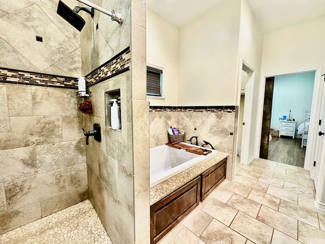 4815 Fm 2827, Warren, TX 77664 - full bath with a garden tub, a tile shower, stone tile flooring, tile walls, and ensuite bath