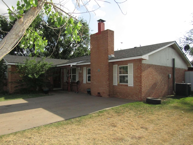 back of house with a lawn, a patio area, and central AC