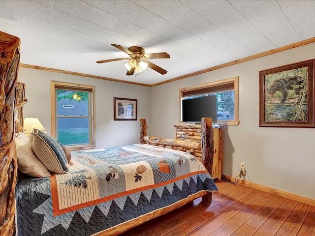 bedroom featuring ceiling fan, wood-type flooring, and ornamental molding