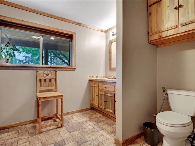 bathroom with vanity, ornamental molding, and toilet