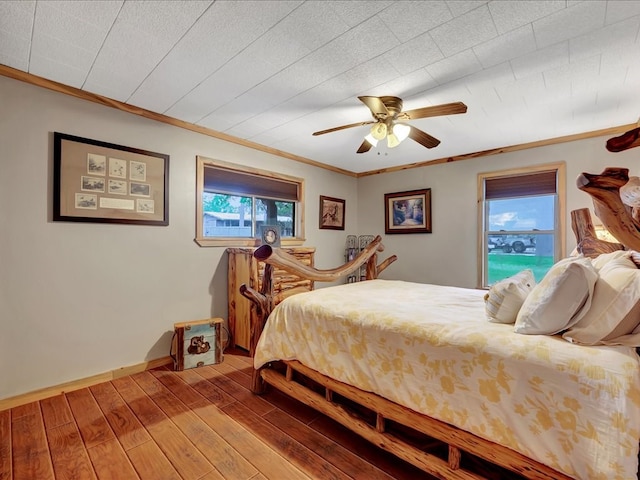 bedroom with ceiling fan, wood-type flooring, crown molding, and multiple windows