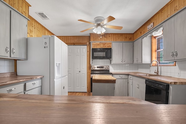 kitchen featuring a sink, decorative backsplash, and black appliances