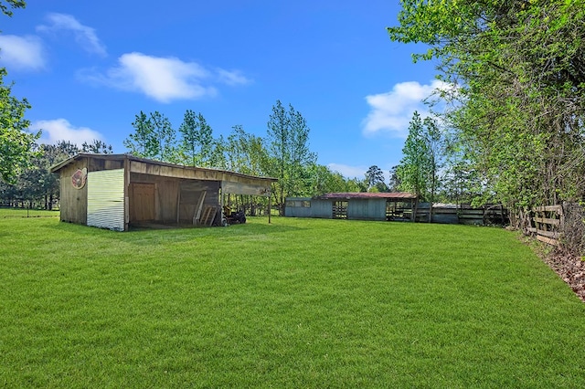 view of yard with an outbuilding, fence, and a pole building