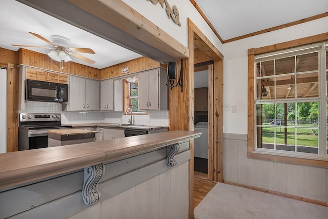 kitchen with a ceiling fan, light wood-type flooring, black appliances, and a healthy amount of sunlight