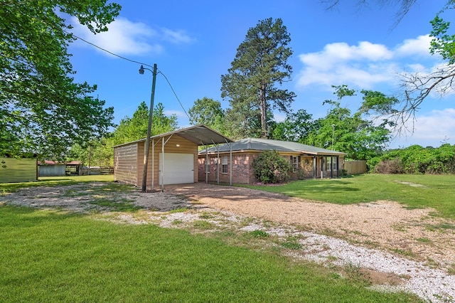 exterior space with a front yard, a carport, fence, an outbuilding, and driveway
