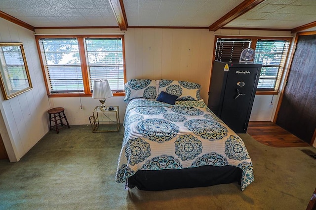 carpeted bedroom with crown molding, wood walls, and multiple windows