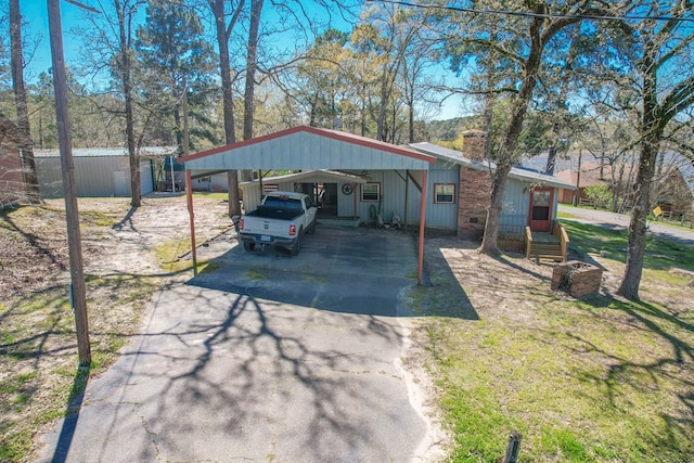 view of vehicle parking featuring a detached carport and aphalt driveway