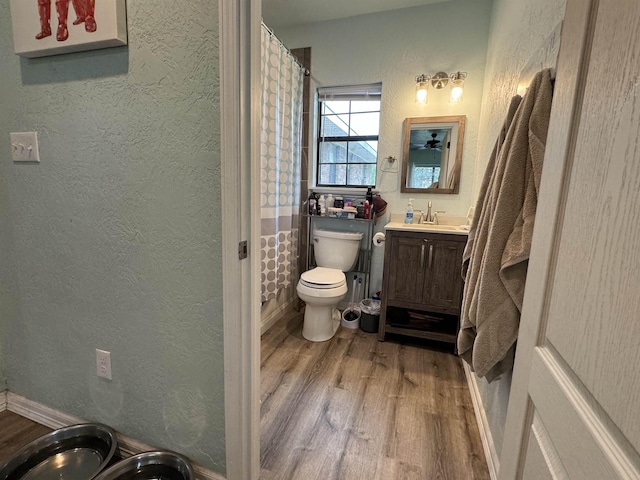 bathroom featuring hardwood / wood-style flooring, vanity, toilet, and walk in shower