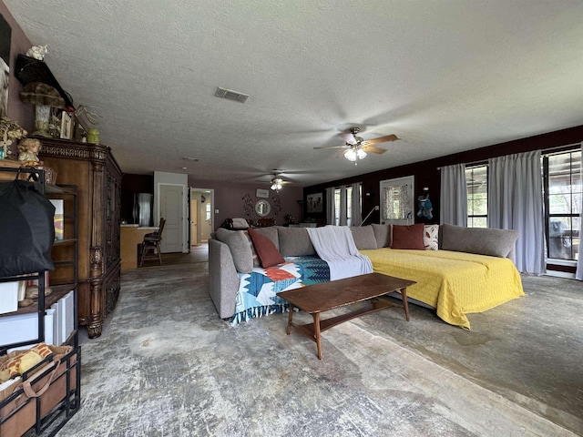 living room featuring ceiling fan and a textured ceiling