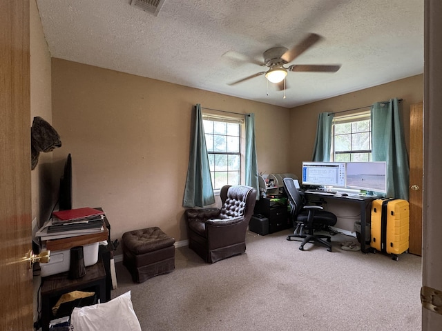 home office featuring carpet flooring, a wealth of natural light, ceiling fan, and a textured ceiling