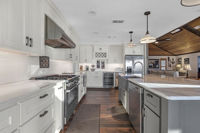 130 Boxwood Ln, Brookeland, TX 75931 - kitchen with stainless steel appliances, beverage cooler, exhaust hood, open floor plan, and dark wood finished floors