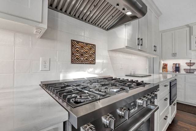 130 Boxwood Ln, Brookeland, TX 75931 - kitchen featuring stainless steel range, premium range hood, white cabinetry, and tasteful backsplash