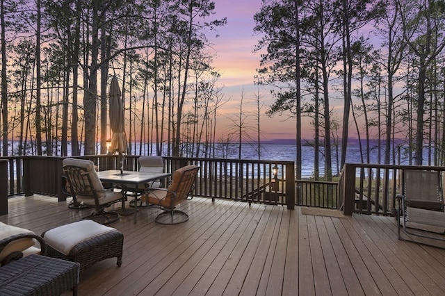 130 Boxwood Ln, Brookeland, TX 75931 - deck at dusk featuring a water view and outdoor dining space