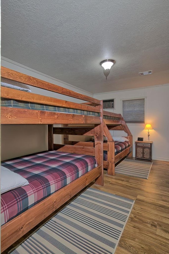 bedroom with wood-type flooring and a textured ceiling