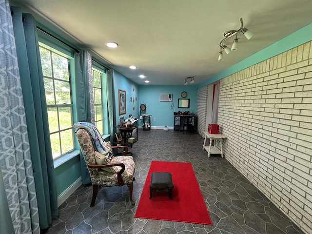 interior space with a wall mounted air conditioner, brick wall, recessed lighting, and stone finish floor