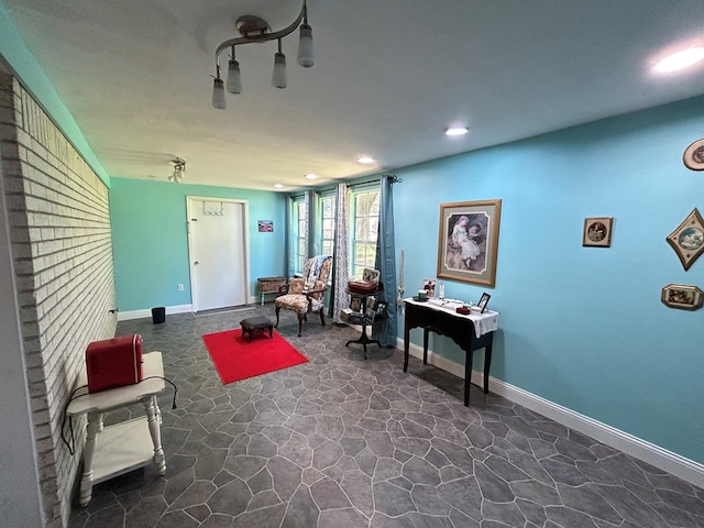 living area featuring baseboards, stone floors, and recessed lighting