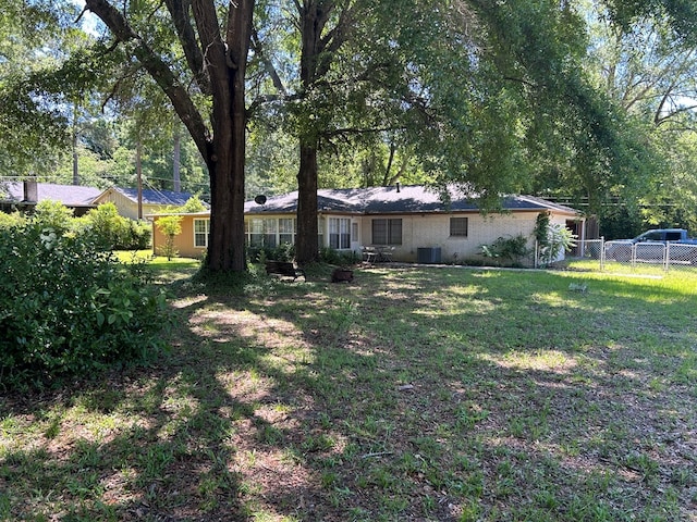 view of yard featuring fence and central AC