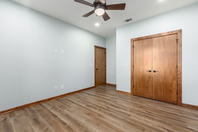 unfurnished bedroom with ceiling fan, light hardwood / wood-style floors, and a closet