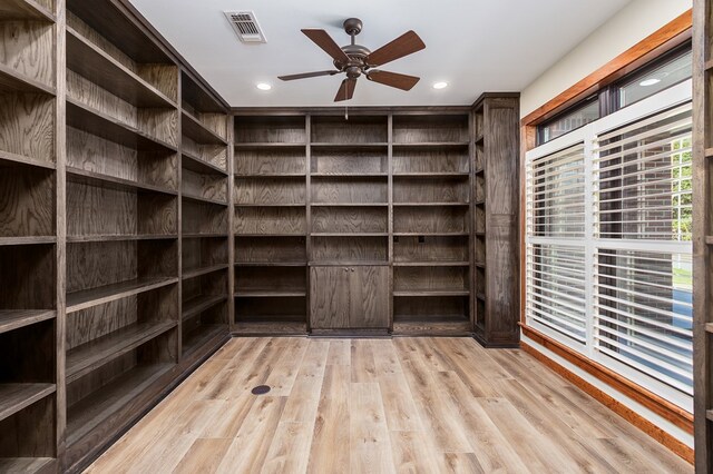 walk in closet with ceiling fan and light hardwood / wood-style floors