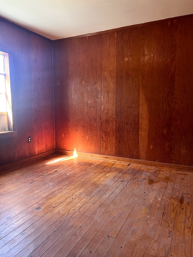 spare room with wooden walls and light hardwood / wood-style flooring