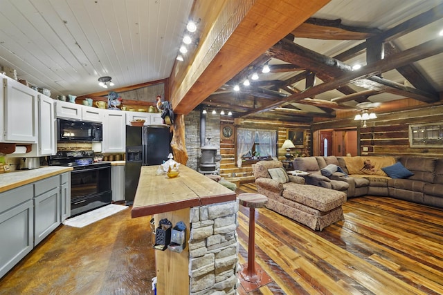 interior space with dark wood-type flooring, black appliances, wooden ceiling, vaulted ceiling with beams, and white cabinetry