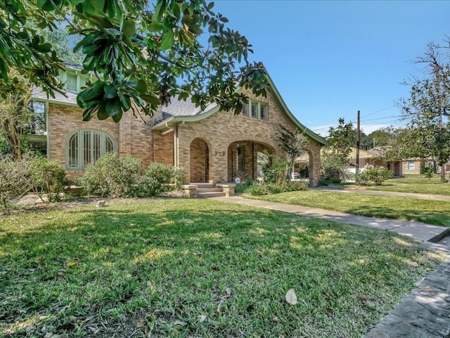 english style home featuring a front yard