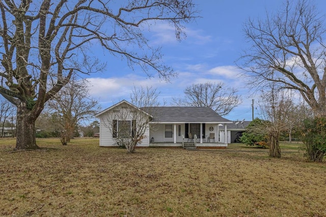 view of front of house with covered porch, a front lawn, and roof with shingles