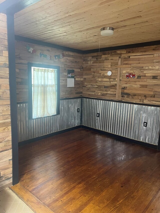 spare room with wood walls, dark wood-type flooring, and wooden ceiling